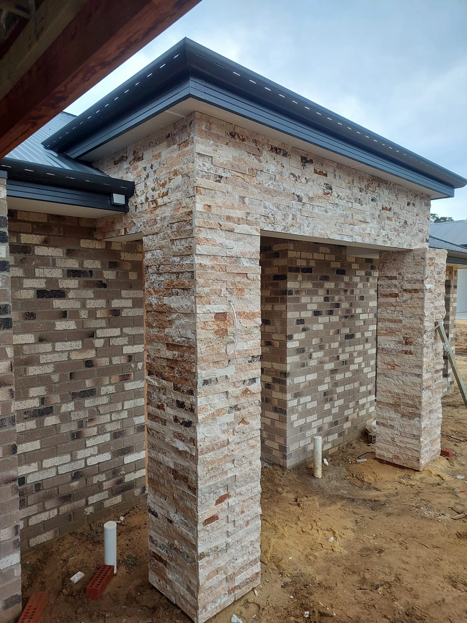 Natural-stone cladding continuing around a residential exterior facade