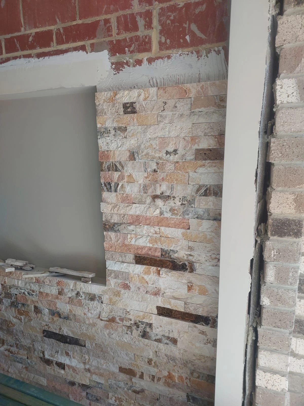 Natural-stone feature tiles fitted around a recessed niche