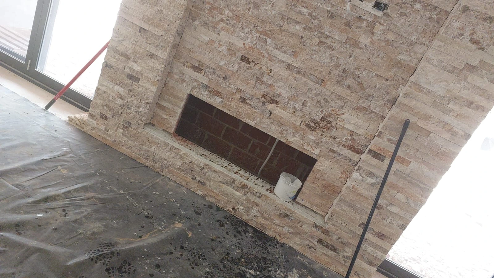 Natural-stone feature wall and fireplace surround under construction